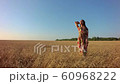 Young woman on wheat field at sunset 60968222