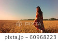 Young woman on wheat field at sunset 60968223
