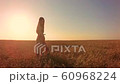 Young woman on wheat field at sunset 60968224