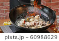 Cooking and mixing seafood in the pan 60988629