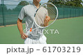 An Asian Tennis Player plays a great shot from the baseline and celebrates game, set and match. 61703219