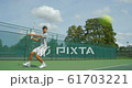 An Asian Tennis Player plays a great shot from the baseline and celebrates game, set and match. 61703221