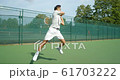 An Asian Tennis Player plays a great shot from the baseline and celebrates game, set and match. 61703222