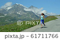 A young European woman running down a mountain in the Alps in the summer. 61711766
