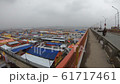 POV man walks on big bridge lookson huge Kumbha Mela tent camp cloudy day 61717461