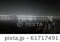 local people walk on bridge across sangam to Kumbha Mela camp lights on other side 61717491