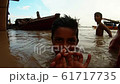 little indian boy splashes up on surface of troubled water another child on background boats 61717735