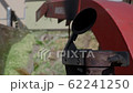 An wood chipper blowing tree branches into a garbage container. 62241250