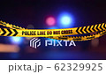 Police barricade warning tape waving in light wind with blurred police car strobing lights in the background . Seamless loop. 3D animation with alpha matte included. 4K 62329925