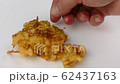 putting fresh deep-fried elderflower fritters onto a white plate closeup 4k 62437163