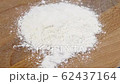 flour is falling onto a wooden cutting board 62437164