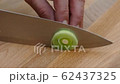 cutting garden leek in slices on a cutting board with a kitchen knife closeup 4k 62437325