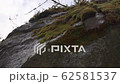 Water drops fall and break on rocks and moss, melting snow in the mountains at spring season, slow motion shot from below slightly movement like dolly effect 62581537