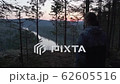Person walking to the rock edge to see beautiful view on river valley from high point of mountain altitude, slow motion epic shot. Sun rising at background. 62605516