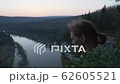 Person looking down at beautiful river valley from high point of mountains, closeup portrait shoot 62605521