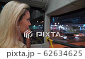 young blonde woman rides a two-tier bus through the night metropolis. In the background of the road 62634625