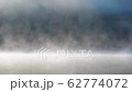 Morning fog in autumn lake landscape. Mountain with trees reflecting in the water 62774072