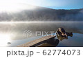 Morning fog in autumn lake landscape. Mountain with trees reflecting in the water 62774073