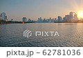 Sunset or dawn in a metropolis. Tall houses, skyscrapers against the orange sun. A water, lake in 62781036