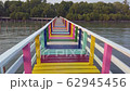 The colorful wood bridge extends into the sea 62945456