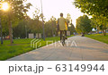 Man in yellow shirt riding a bike 63149944