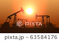 Working oil pump jacks in a desert against sunset extracting crude oil 63584176