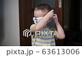 Funny kid putting on medical mask. Quarantine, staying at home. Slow motion 63613006