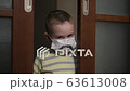 Sad boy in medical mask, looking at camera despleased . Virus protection, pandemic, prevention epidemic. 63613008