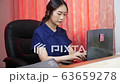 Woman working at home while typing on computer	 63659278