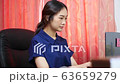 Woman working at home while typing on computer	 63659279