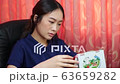 Woman looks at the calendar to see the long holiday of the year.	 63659282