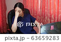 Woman sitting on a computer bored of working	 63659283