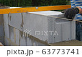 Bricklayer putting down another row of bricks in site 63773741