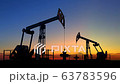 Two oil pump jacks extracting crude oil under beautiful sunset sky 63783596