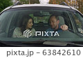 happy couple chat and drive on road in the car 63842610