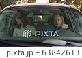 a man and a woman are riding in a car with no seat belts 63842613