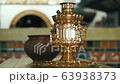 Antique metal bronze russian samovar. Objects ancestral way of life. Blurred background of the Russian furnace. 63938373