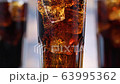 Closeup bubbles in glass with cola and ice cubes. Bubbles rise up of fizzy drink. Macro 63995362