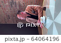 vertical video, a handsome guy drinks coffee alone in a cafe and writes on a smartphone 64064196