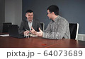 Men making agreement at table in office 64073689