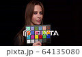 Young Woman holding up a color checker card 64135080