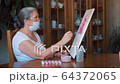 Senior woman painting at home during self isolation quarantine coronavirus 64372065