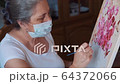 Adult Female painting at home quarantine wearing medical mask  64372066