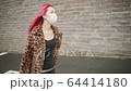 Beautiful young asian girl with colored hair in medical mask walk street. 64414180