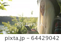 Charming young woman with a magnificent golden hair, black sunglasses, Attractive young lady is chilling on the nature, she doing something in her smartphone. Camping, Travel, Nature, Forest. FullHD 64429042
