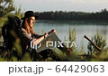 Handsome young man on a hat looking at map, thinking about his route across the forest. Camping. Summer. FullHD video. 64429063