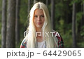 Charming young woman portrait. With a magnificent golden hair, big brown eyes, Attractive young lady is chilling on the nature, looking in camera. Camping. Summer. FullHD video. Travel. 64429065