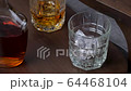 Golden whiskey or bourbon pouring in glass. Cognac or rum flowing in glass in slow motion. Drink Concept 64468104
