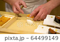 A chef of a fancy Japanese restaurant foriming sea urchin nigiri sushi 64499149
