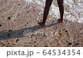 Young child playing in the shallow waves on Brighton beach, England 64534354